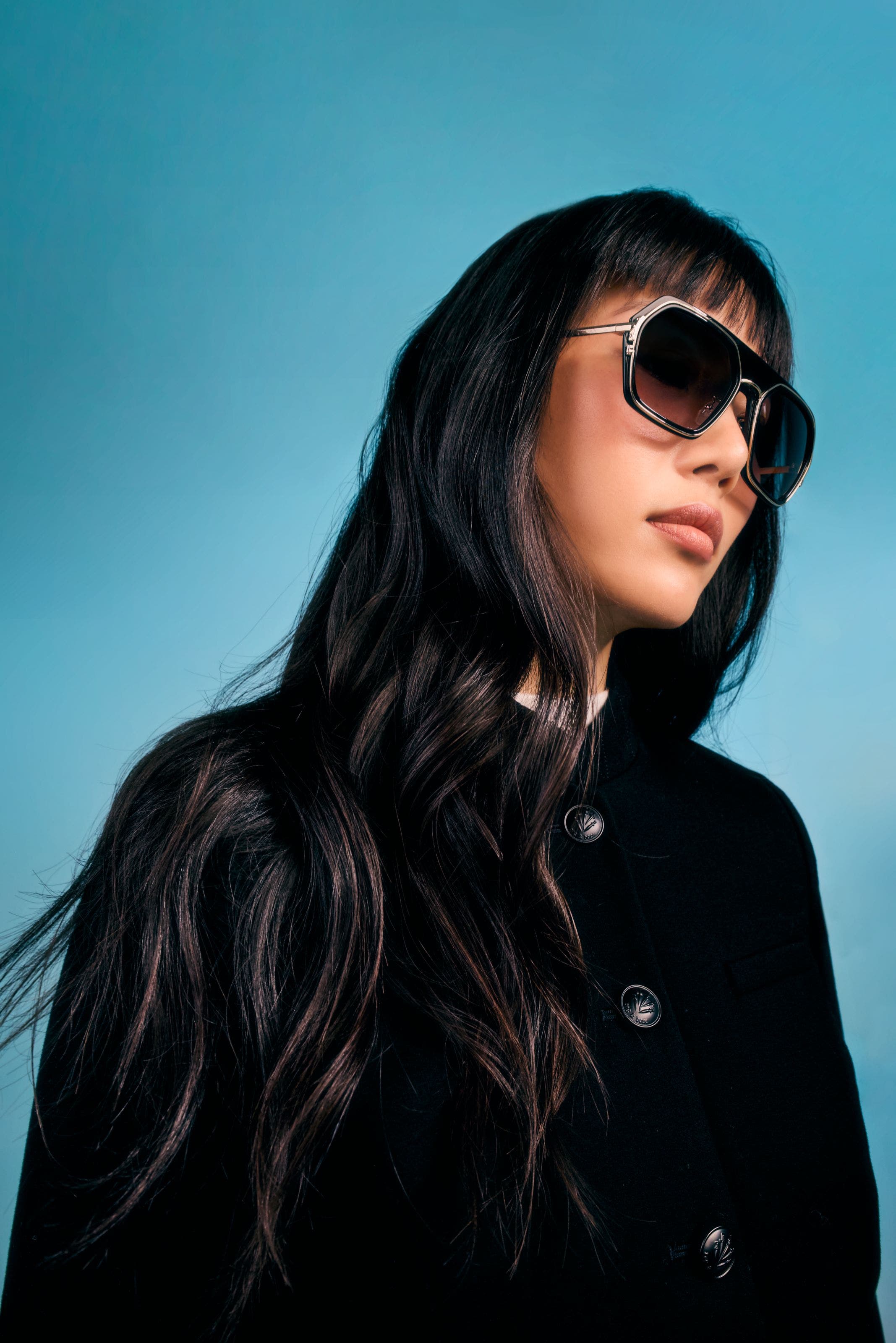 Women in black jacket and large black sunglasses.
