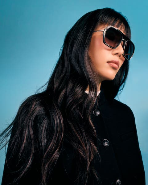 Women in black jacket and large black sunglasses.