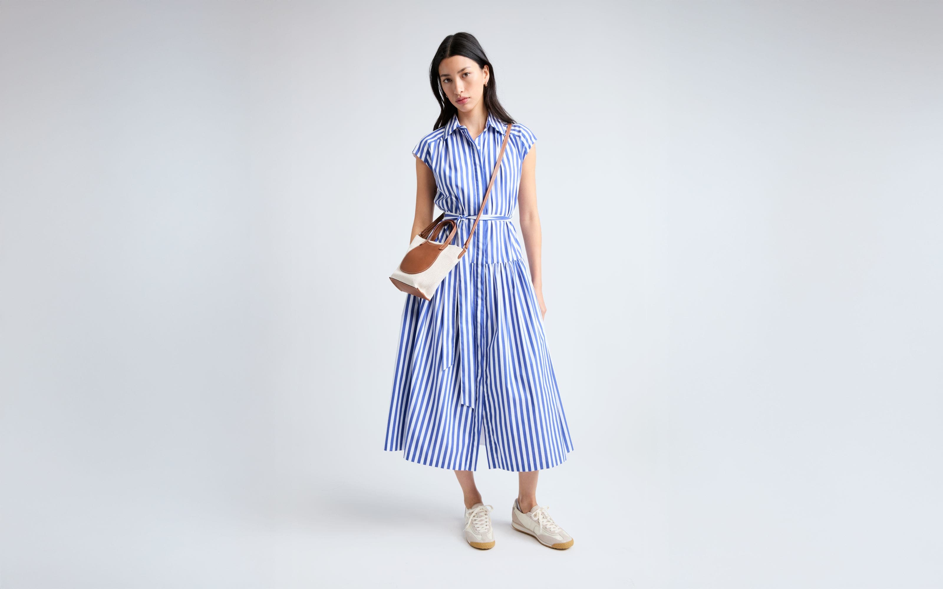 A woman wearing a blue stripe shirtdress. 