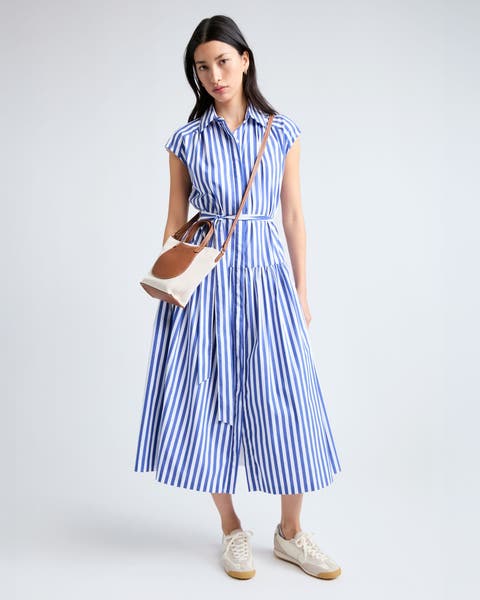 A woman wearing a blue stripe shirtdress.