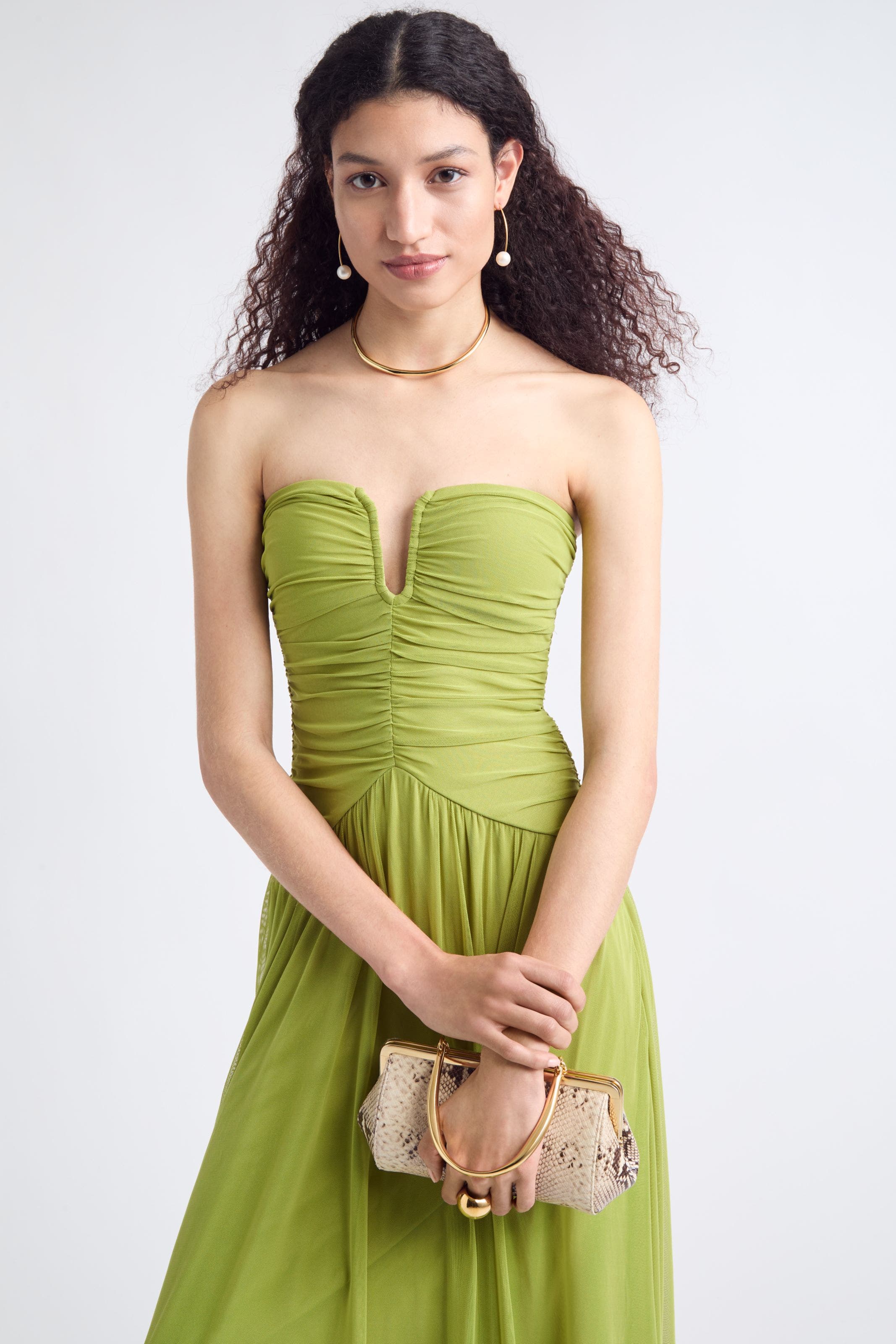 A woman carrying a snakeskin print evening bag.