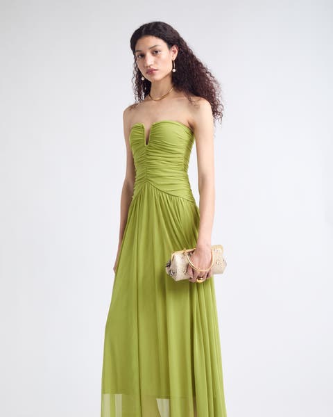 A woman wearing a green strapless cocktail dress.  