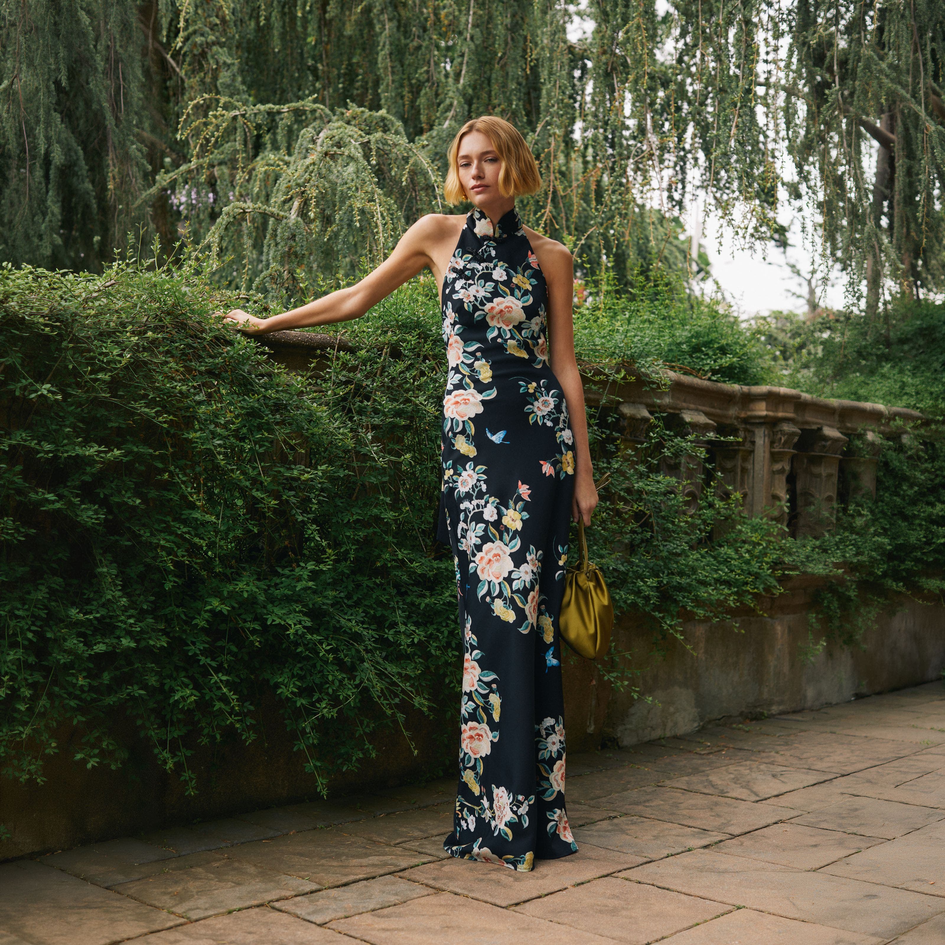 Woman in floral evening dress outdoors.