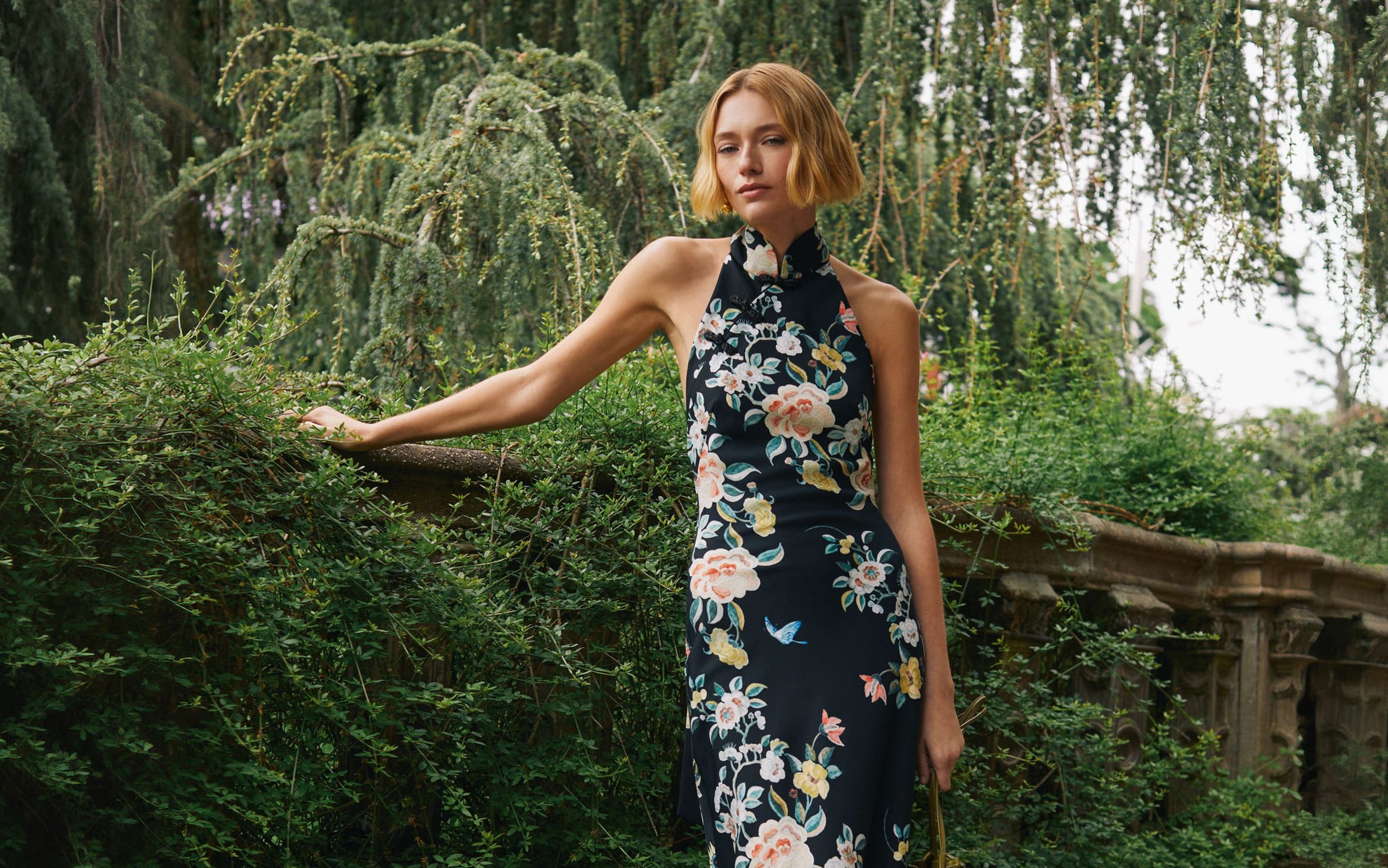 Woman in floral evening dress outdoors.