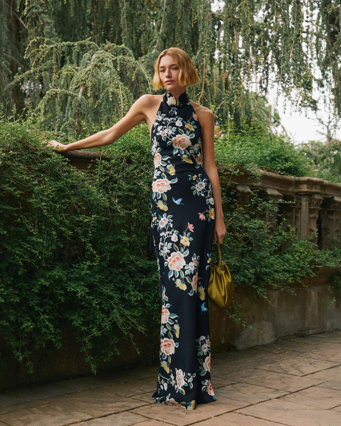Woman in floral evening dress outdoors.