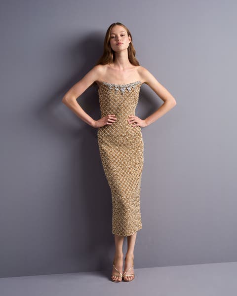 A woman in a gold embellished strapless dress.