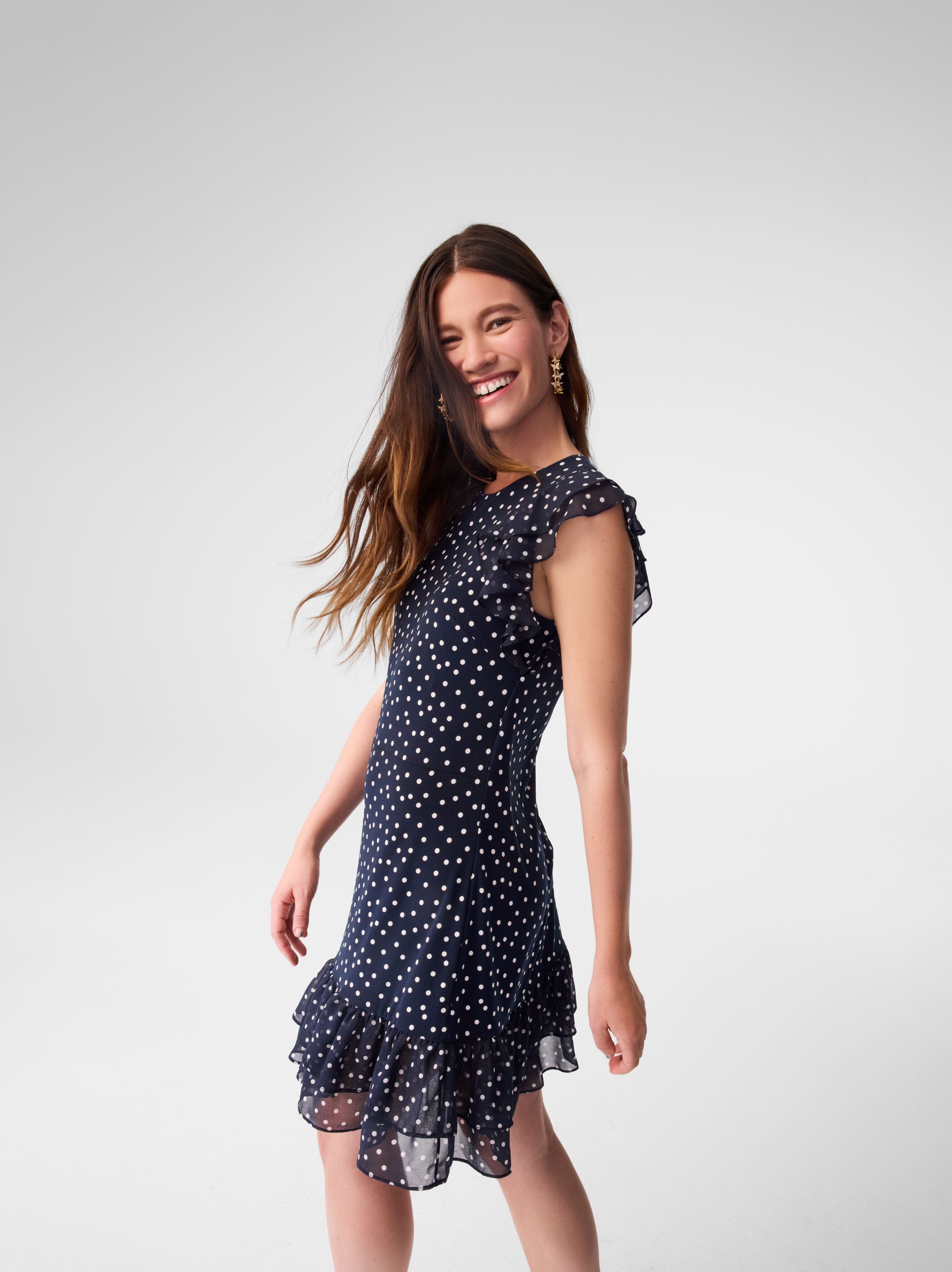 A woman wearing a navy dress with white dots. 