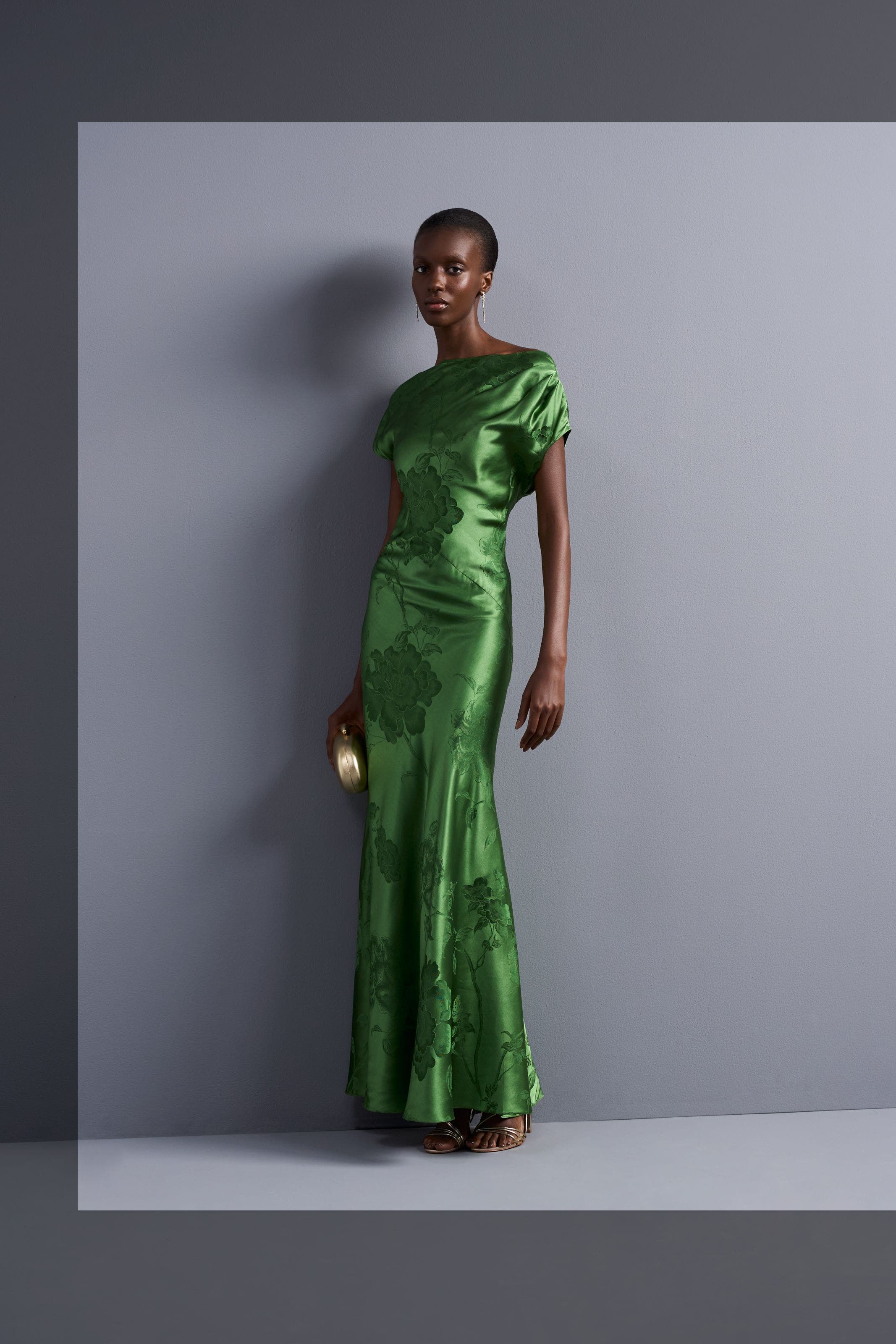 A woman in a green satin draped gown.