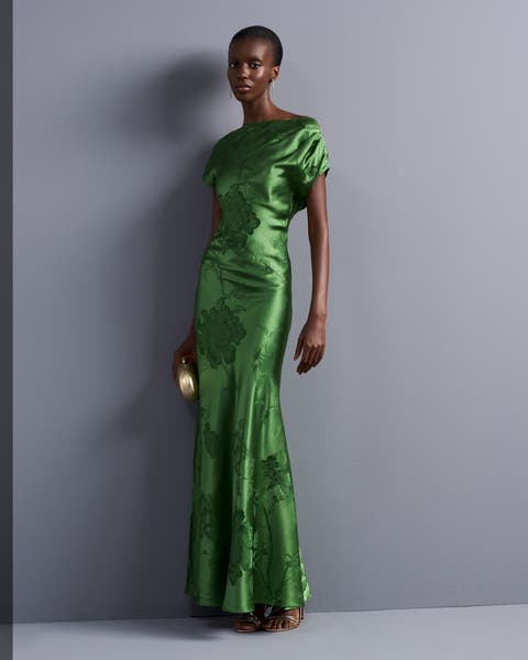A woman in a green satin draped gown.