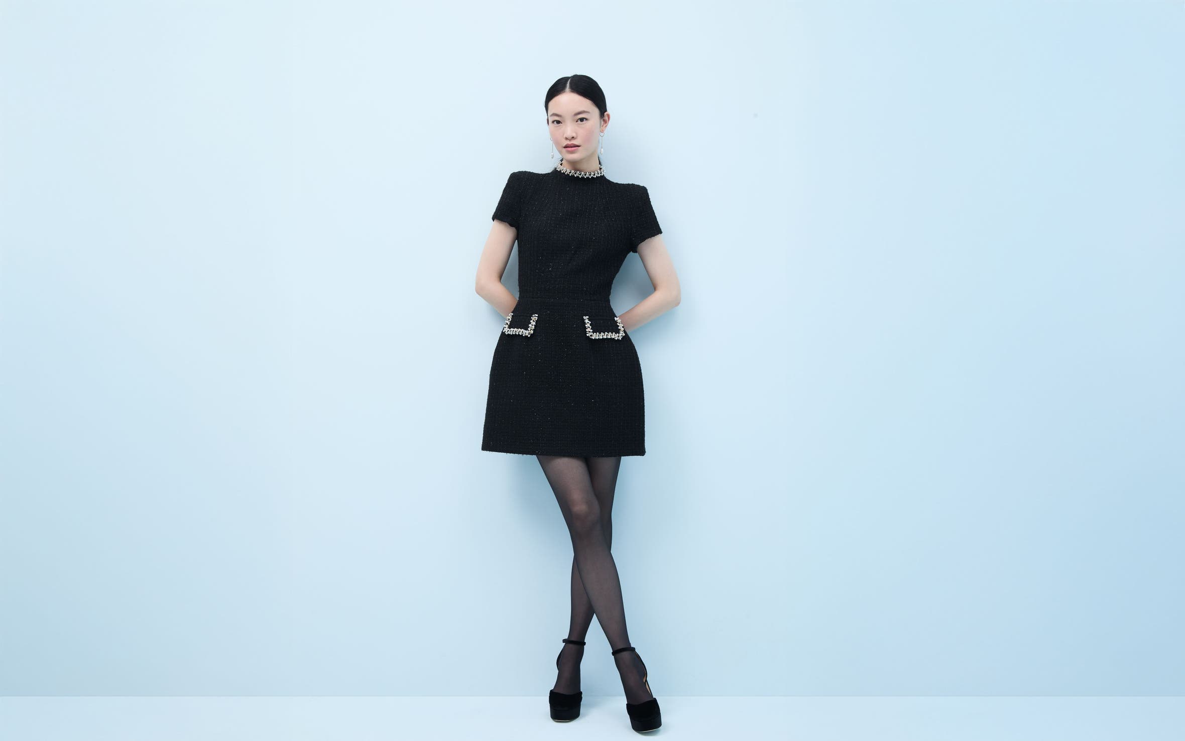 Woman wearing a little black dress with embellishment.