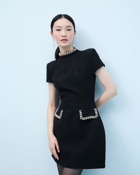 Woman wearing a little black dress with embellishment.