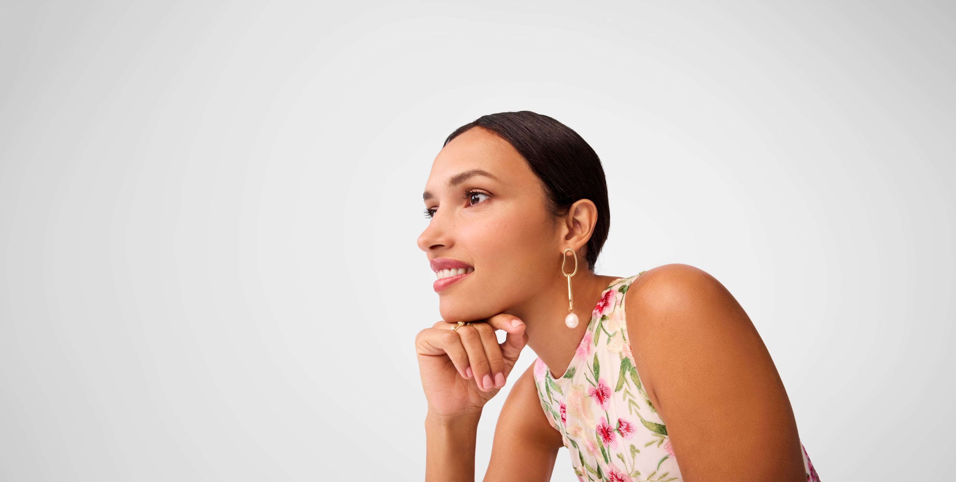 A woman wearing pearly drop earrings. 