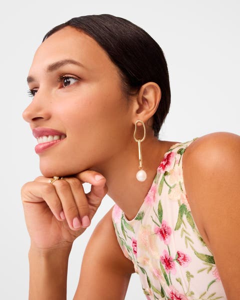 A woman wearing pearly drop earrings.