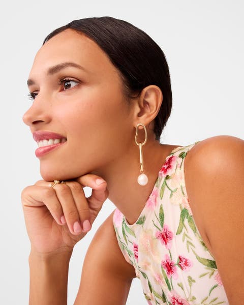 A woman wearing pearly drop earrings.