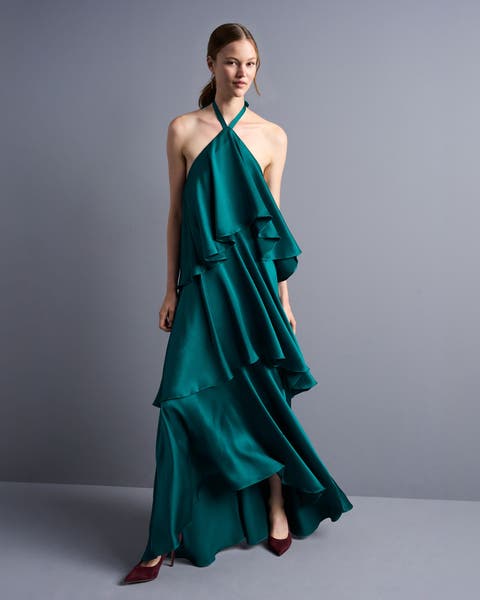 A woman in a dark teal tiered halter gown.