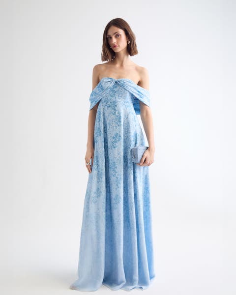 A woman wearing a floral-print off-the-shoulder gown.
