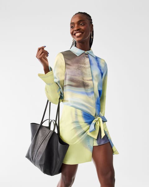 A woman wearing a yellow printed minidress.