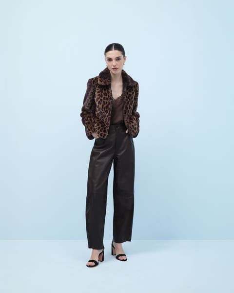 Woman wearing a leopard jacket, top, pants and heels.