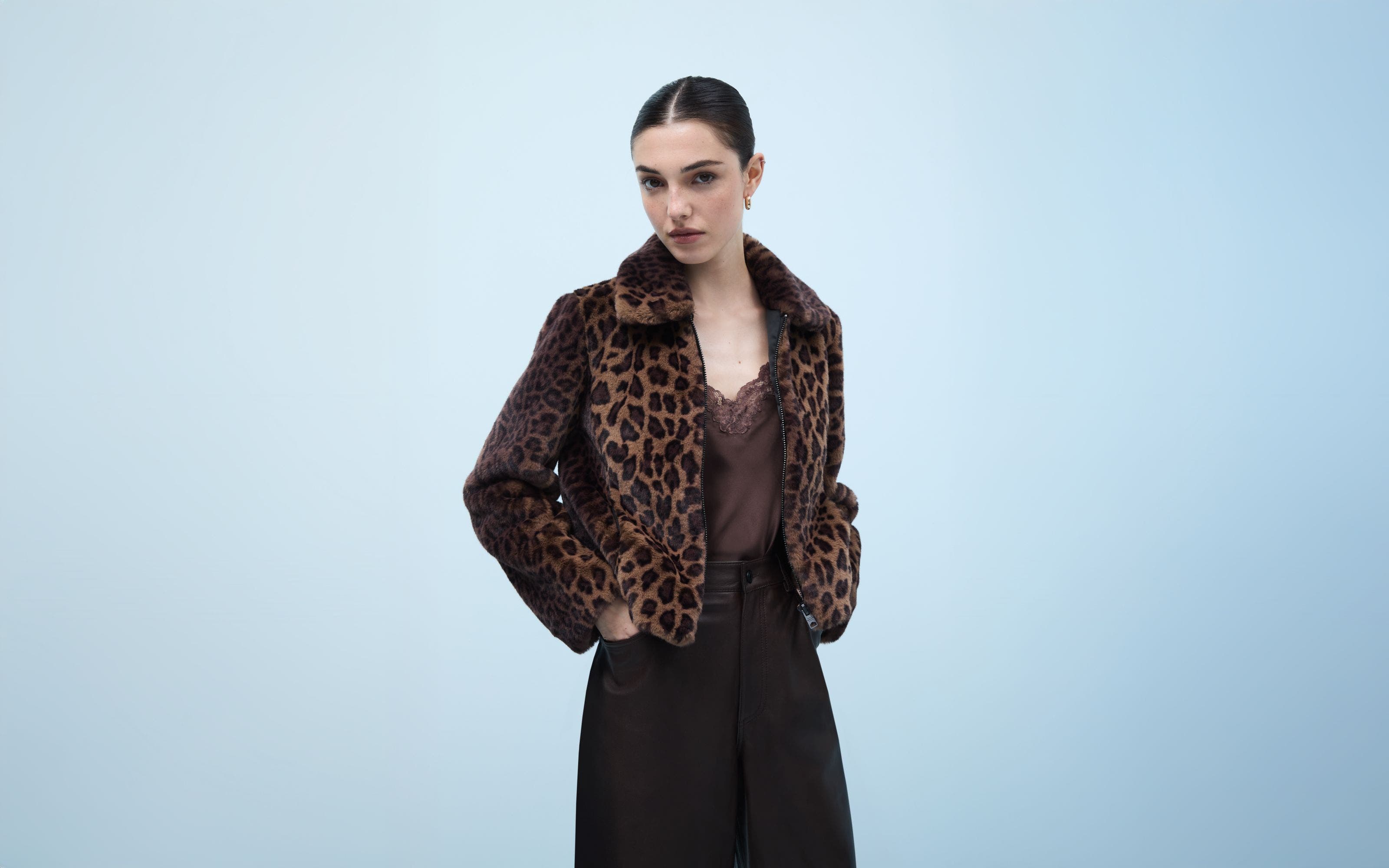 A woman wearing an animal-print coat over a lace-trimmed camisole.
