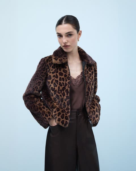 A woman wearing an animal-print coat over a lace-trimmed camisole.