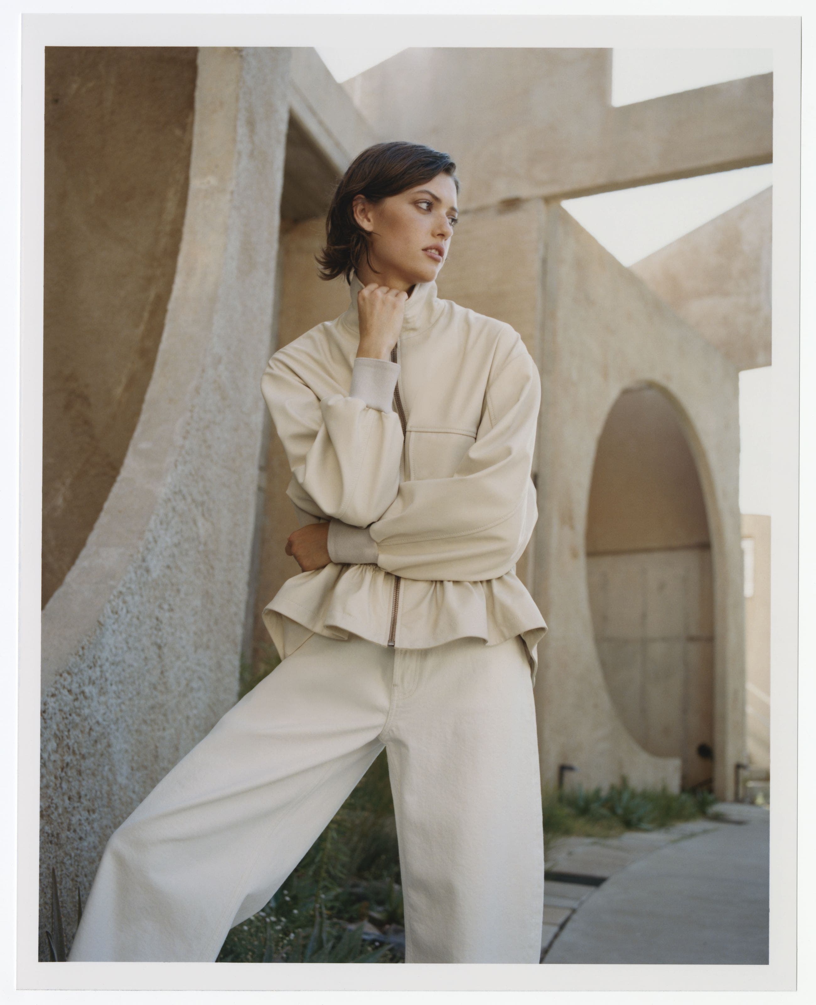 Woman wearing an off-white jacket and trousers.