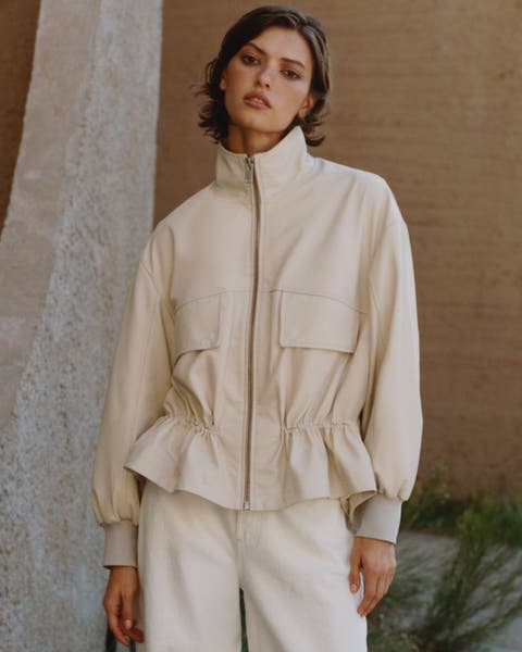 A woman wearing a cinched leather jacket.