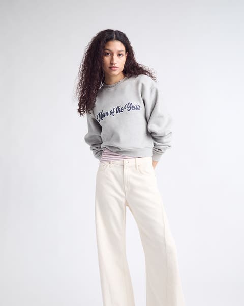 A woman wearing a "Mom of the Year" sweatshirt. 