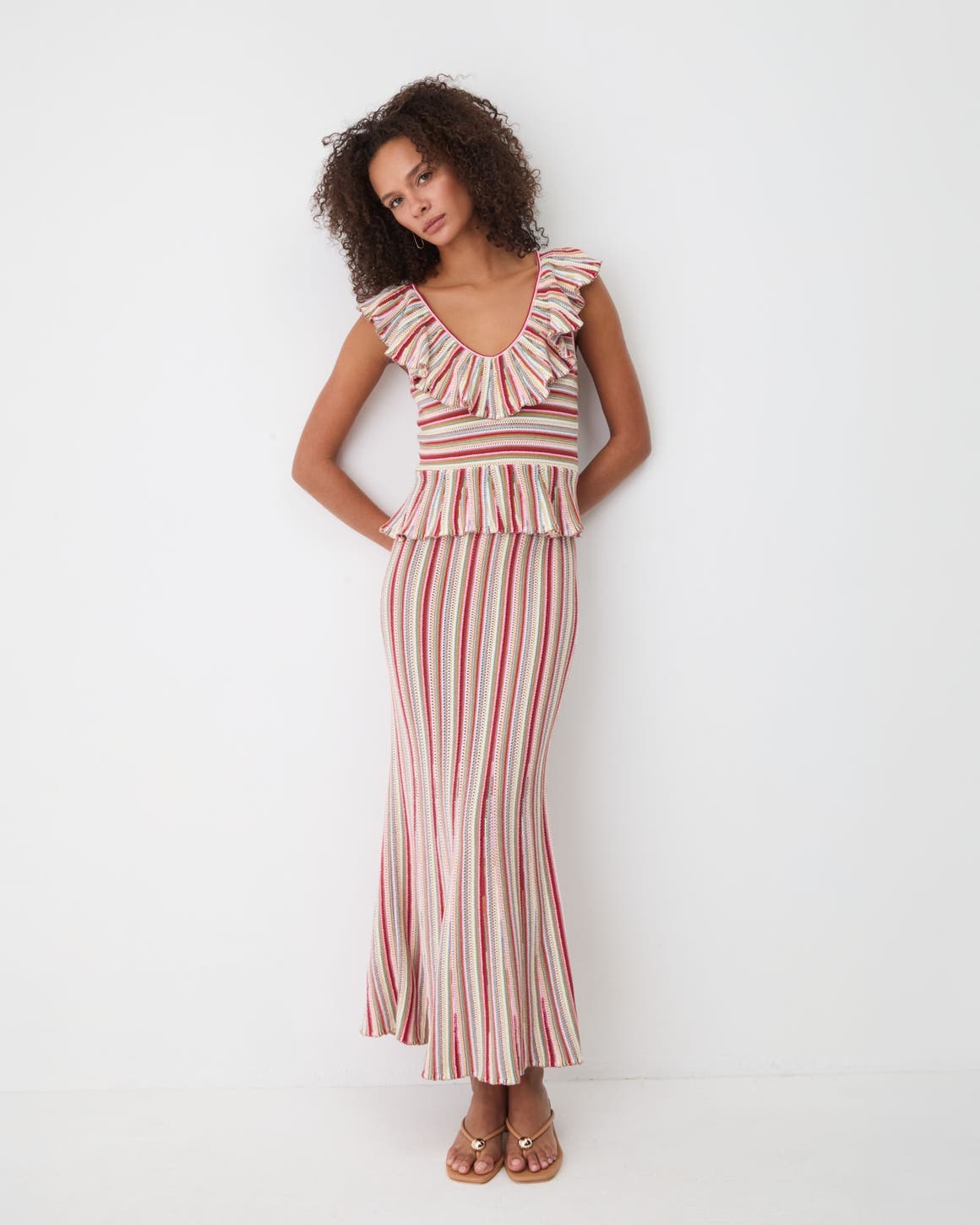 Woman wearing matching stripe top and skirt set.