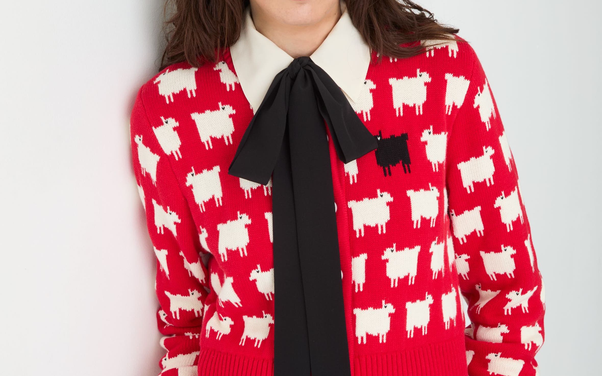 Woman wearing red patterned sweater and bow
