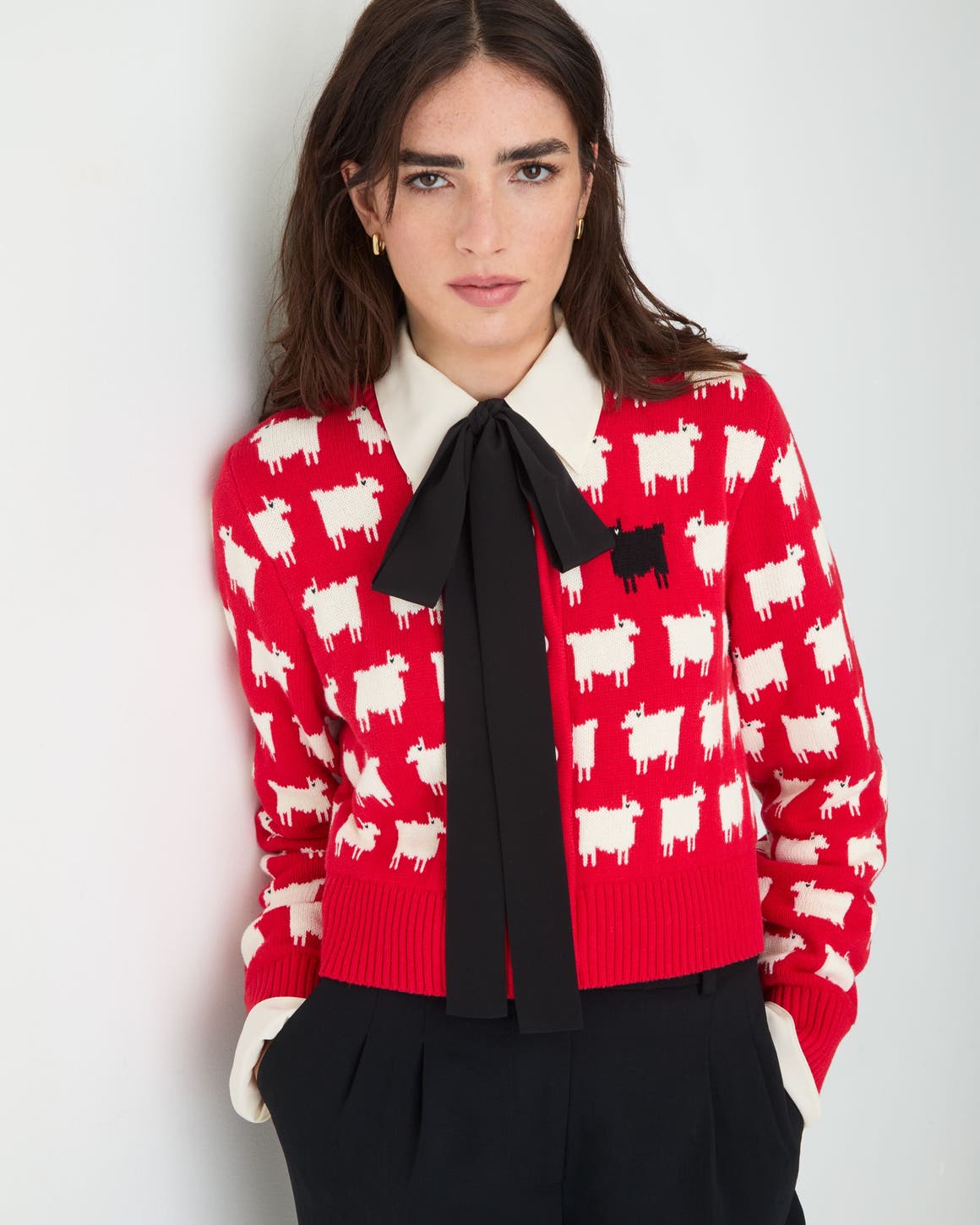 Woman wearing red patterned sweater and bow
