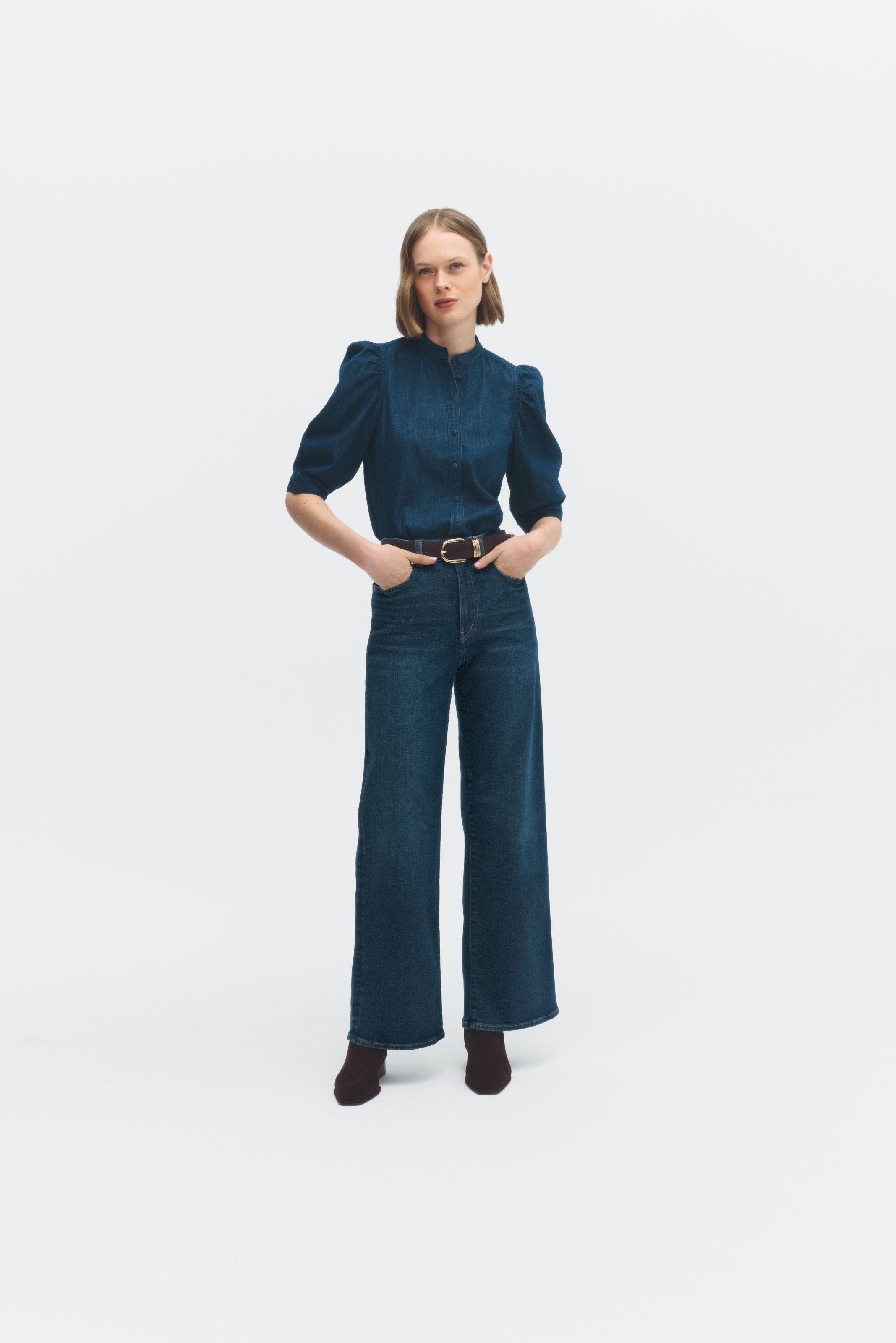 A woman wearing a puff-sleeve top with jeans.