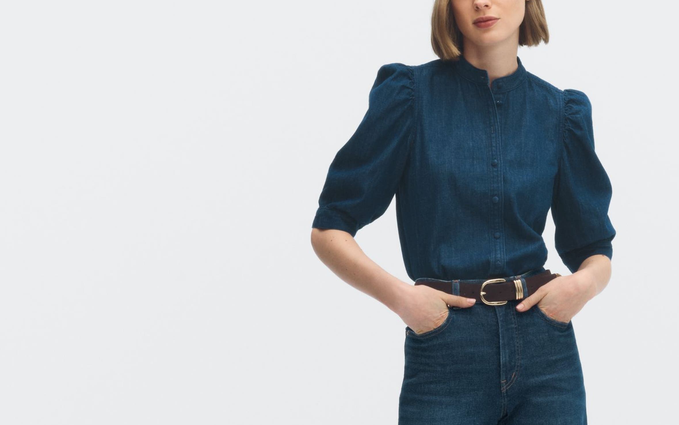 A woman wearing a puff-sleeve top with jeans.