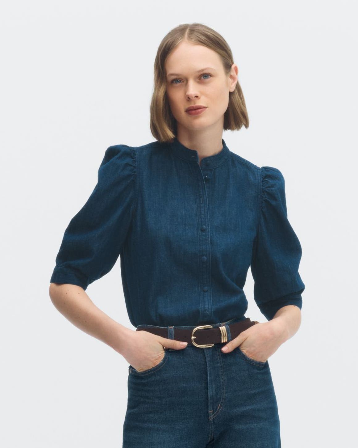 A woman wearing a puff-sleeve top with jeans.