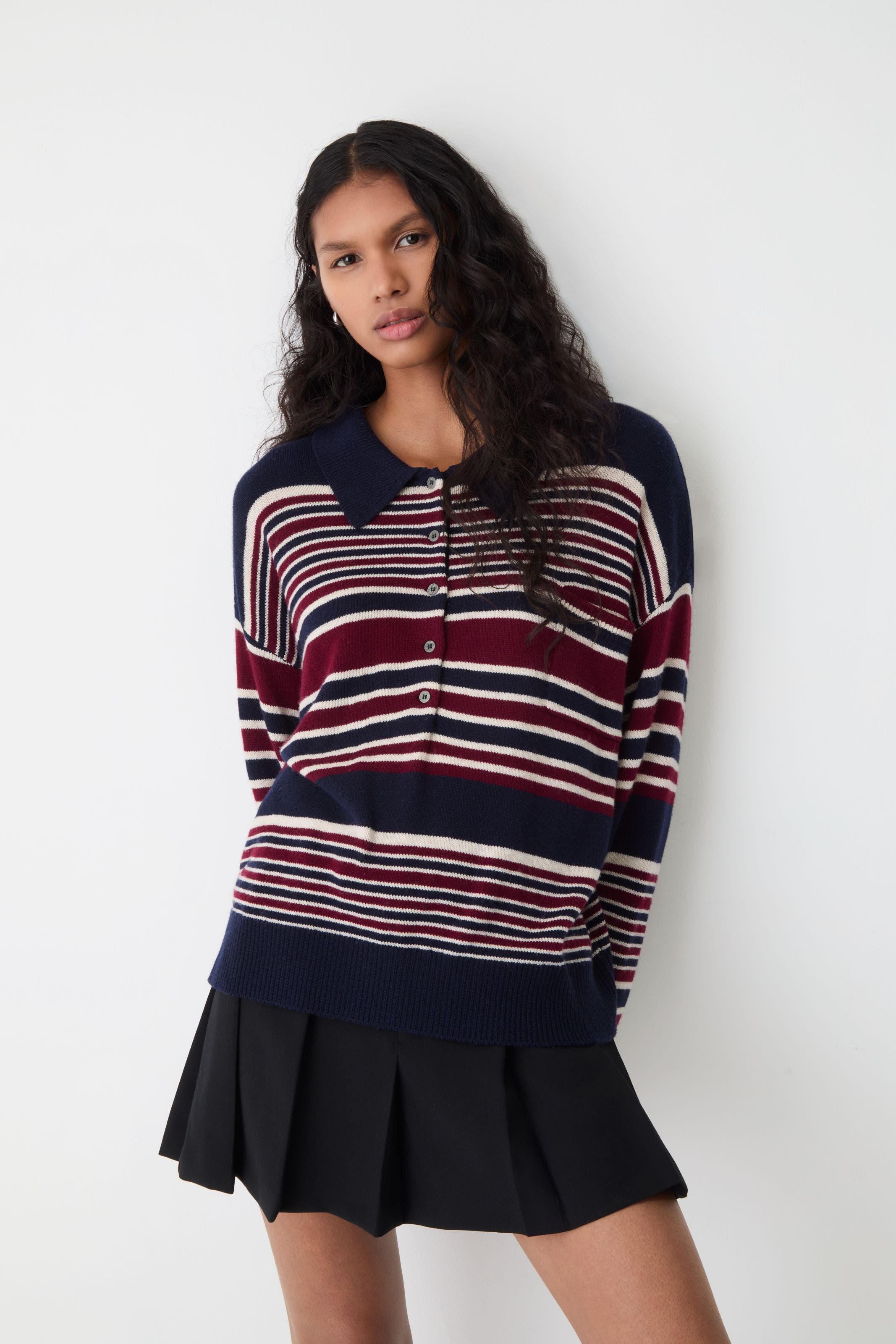 A woman wearing a striped polo sweater with a collar.