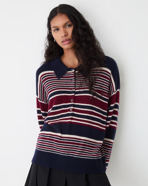 A woman wearing a striped polo sweater with a collar.