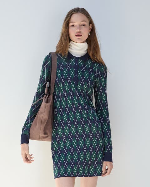 A woman wearing an argyle sweater dress and Hunter boots.