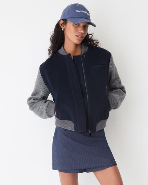 A woman wearing a bomber jacket and mini skort.