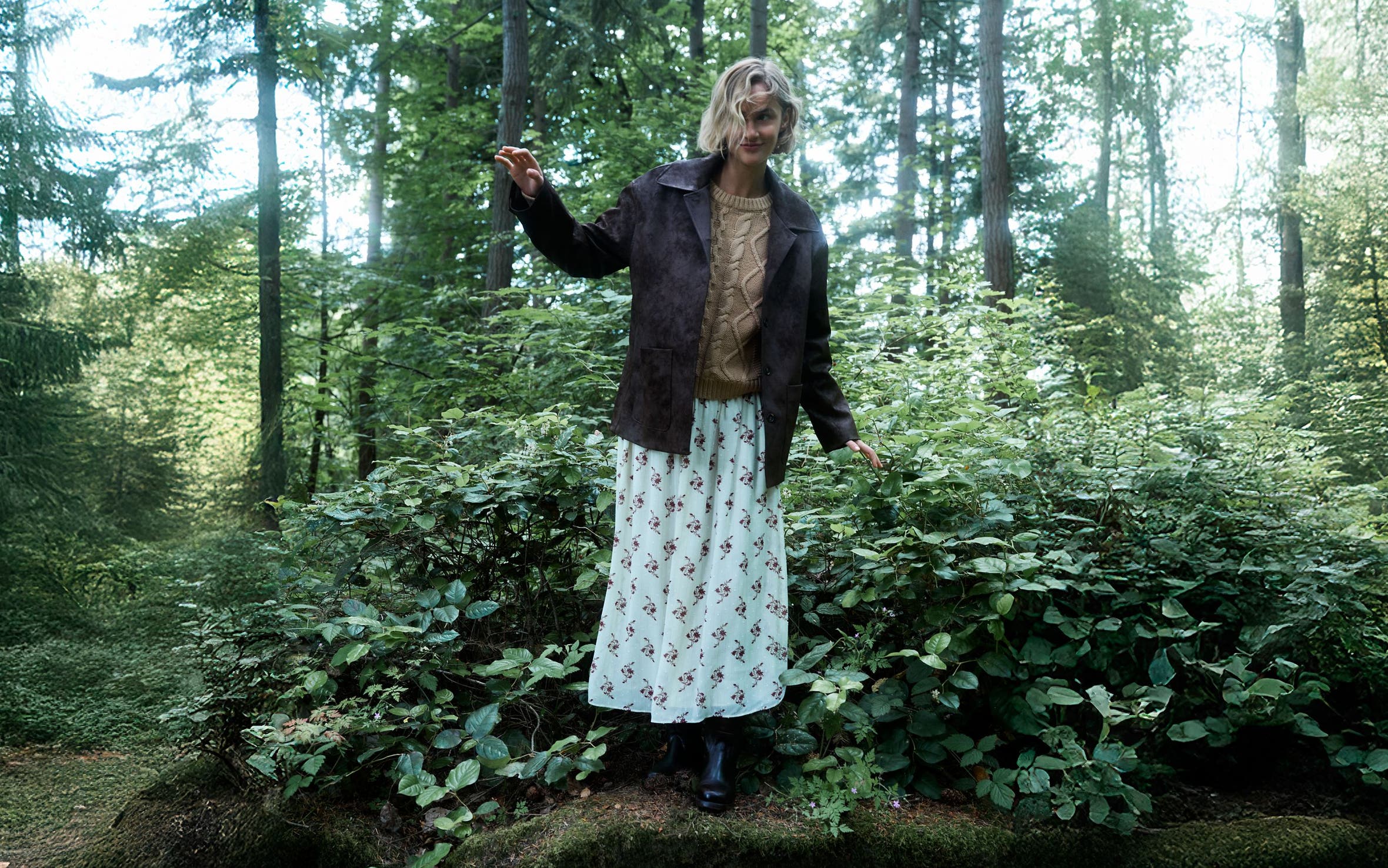 A woman standing in a forest.