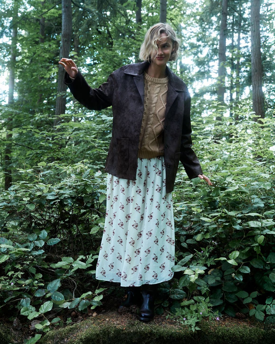 A woman standing in a forest.