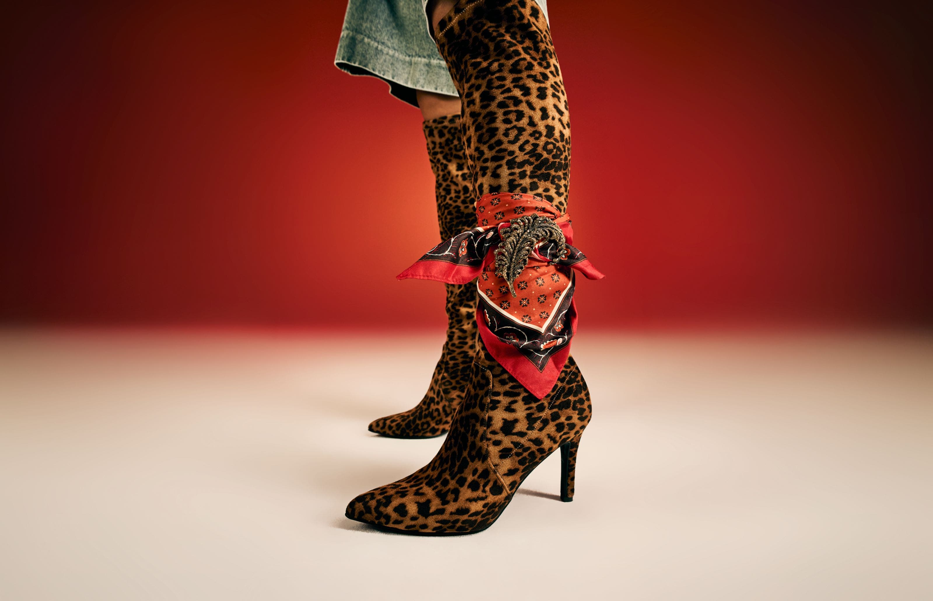 A woman wearing tall leopard-print boots. 