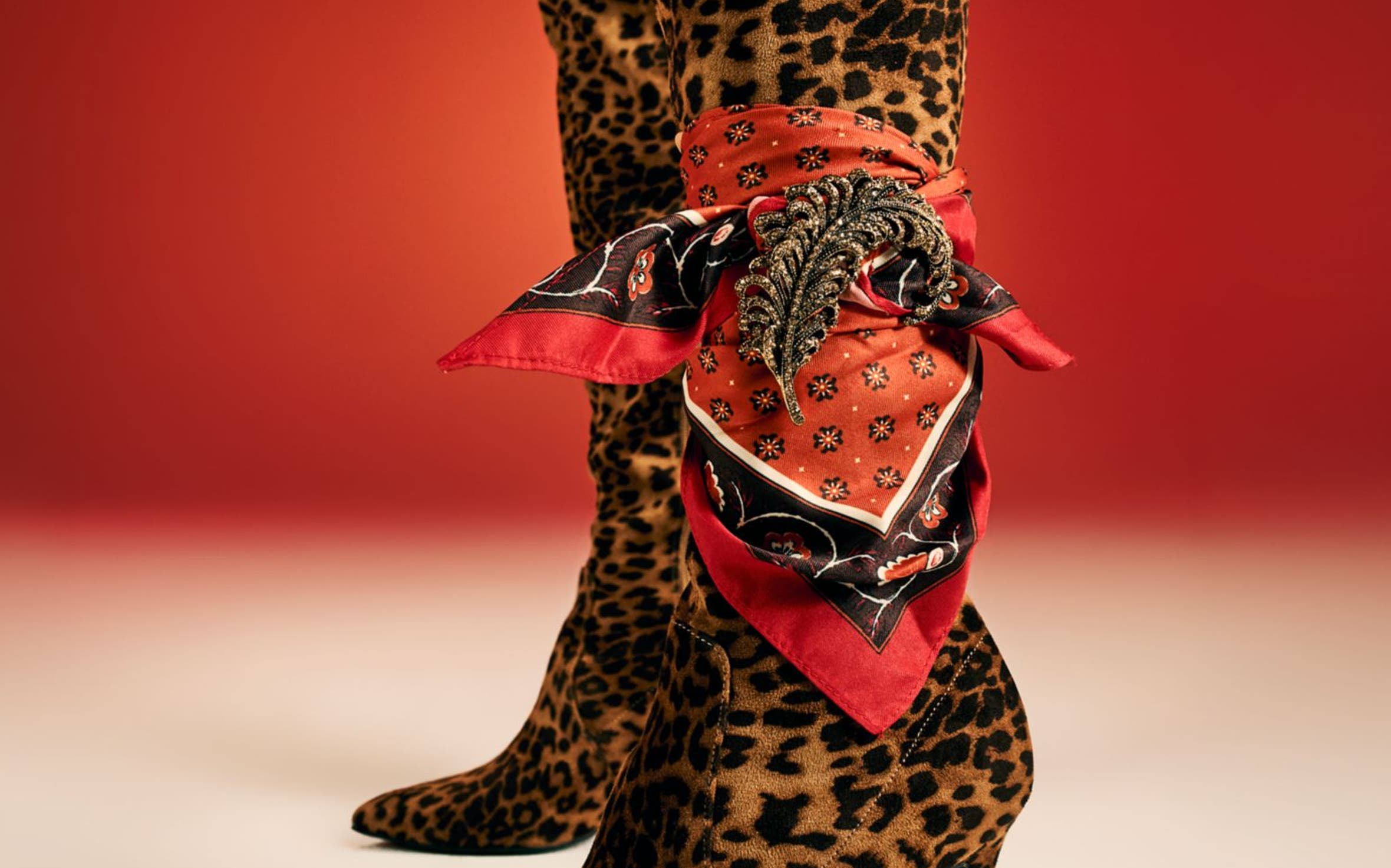 A woman wearing tall leopard-print boots. 