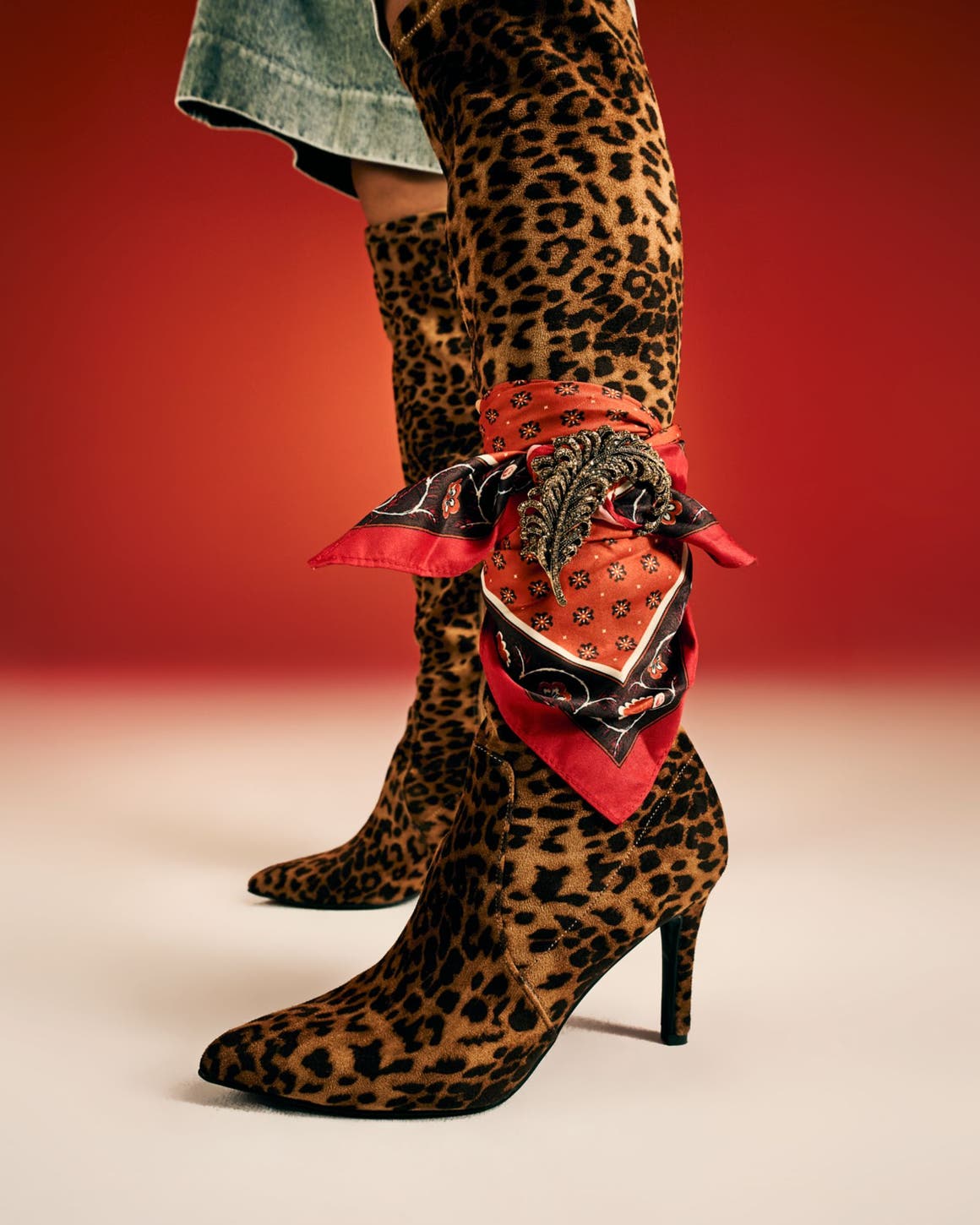 A woman wearing tall leopard-print boots. 