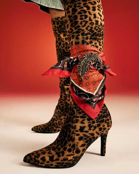 Leopard-print over-the-knee stiletto boots styled with a red silk scarf.