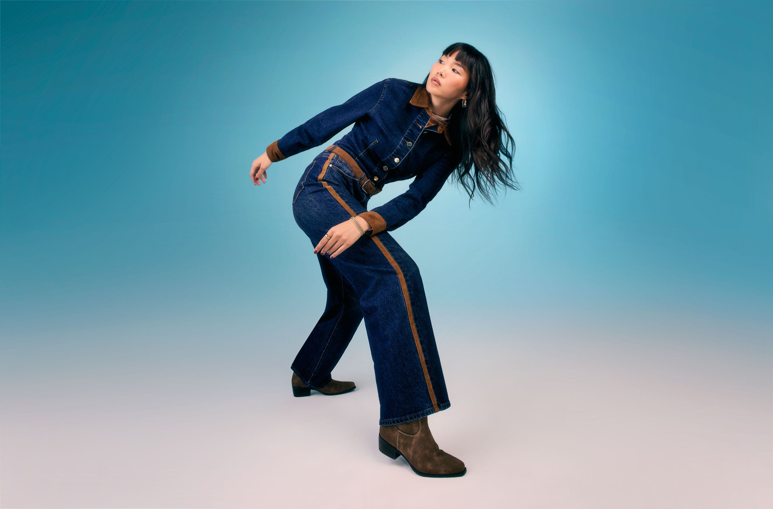 A woman wearing a blue denim jumpsuit.