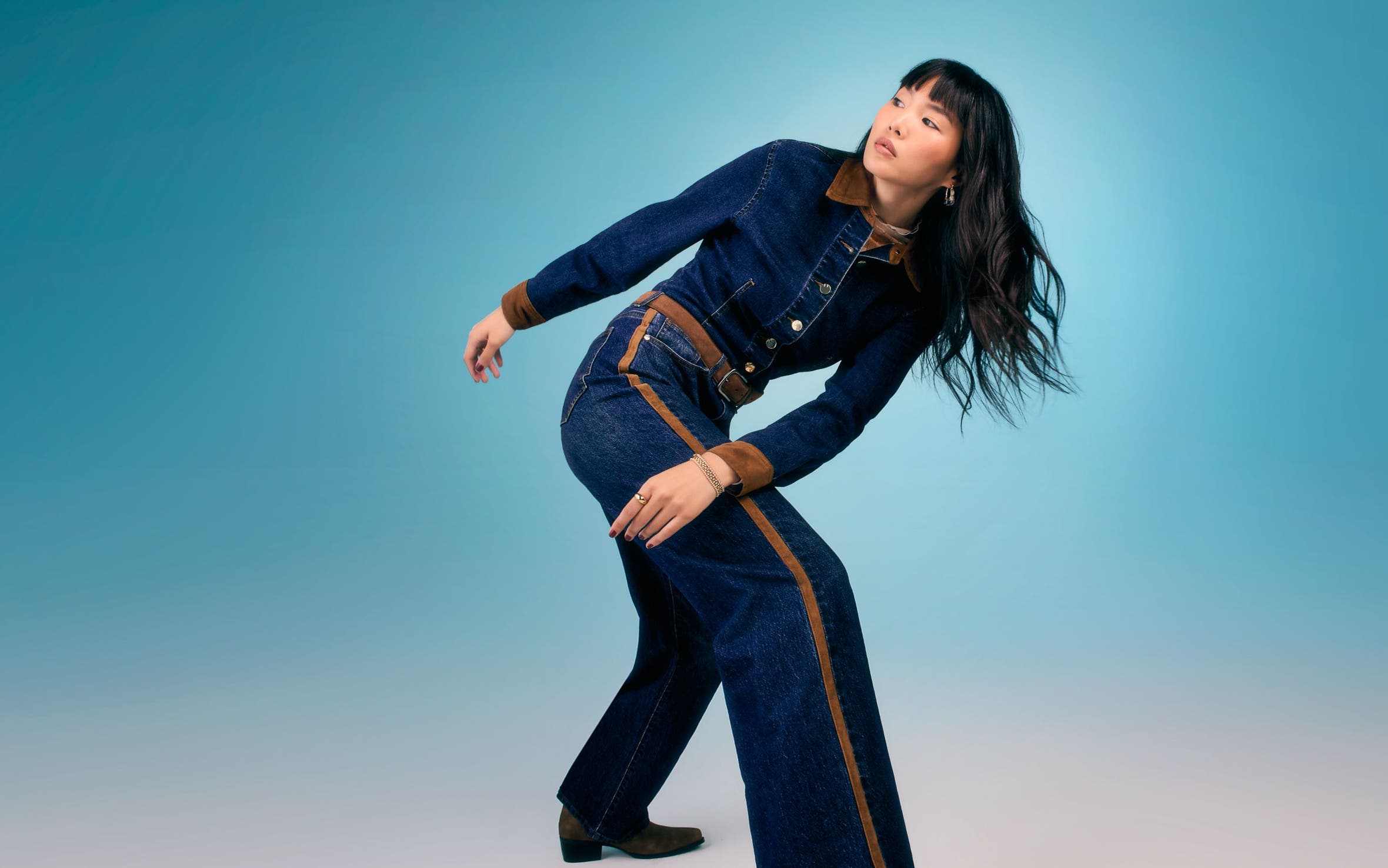 A woman wearing a blue denim jumpsuit.