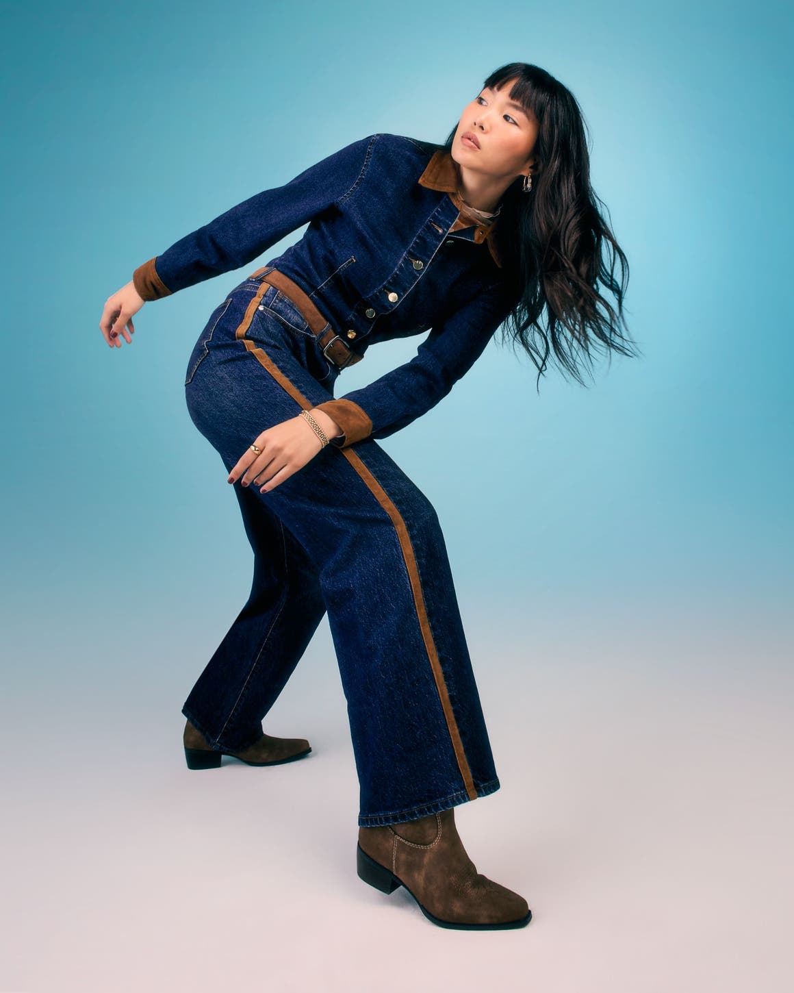 A woman wearing a blue denim jumpsuit.