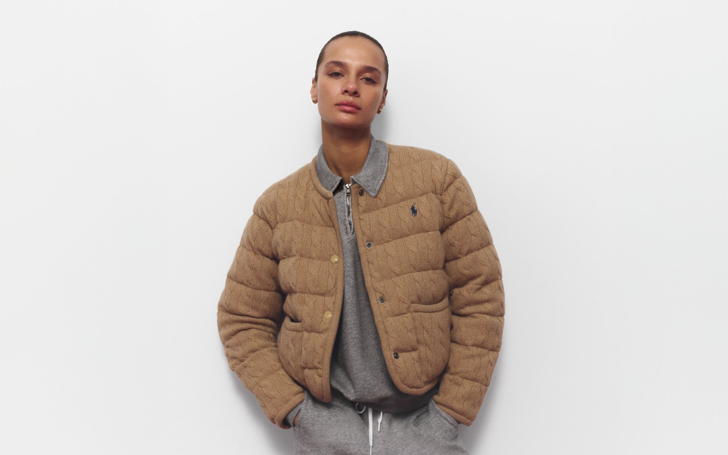 A woman wearing a sweatshirt and matching joggers with a quilted jacket.