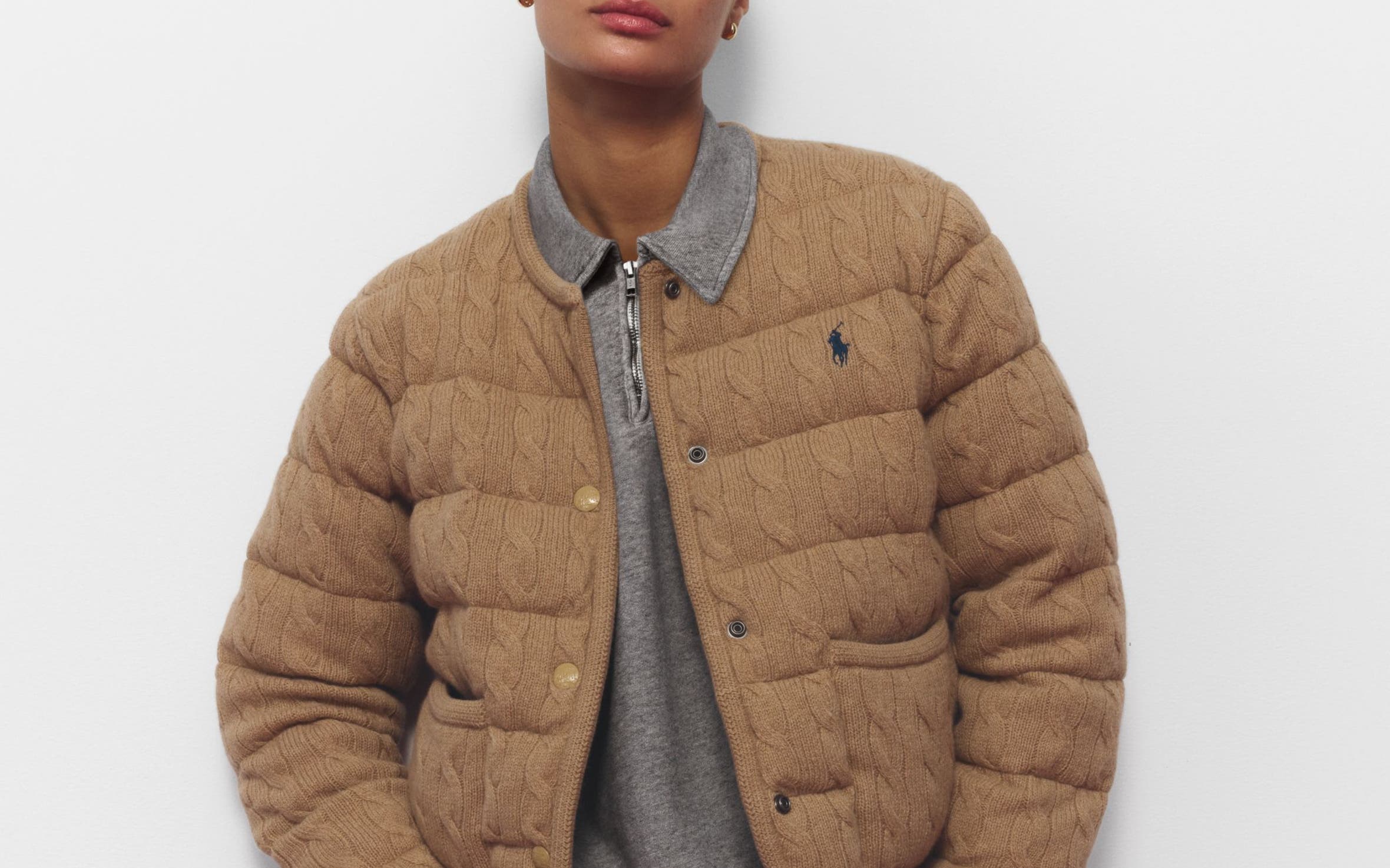 A woman wearing a grey sweatsuit and lightweight puffer jacket.