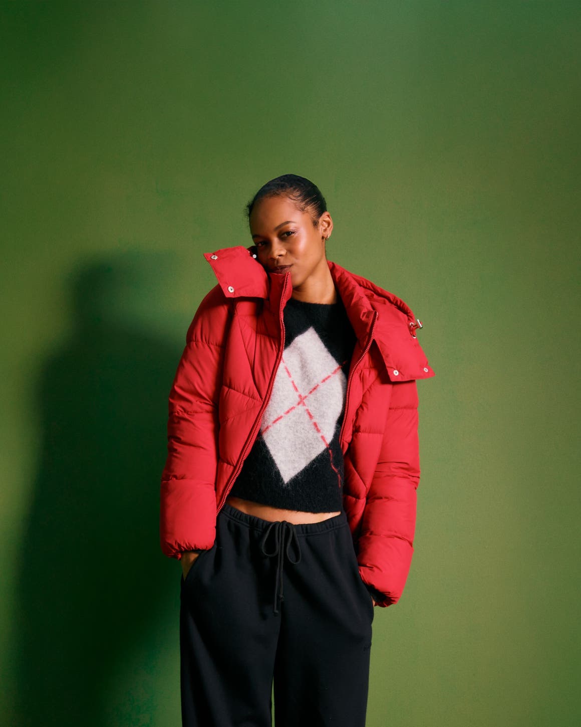 Woman wearing a puffer, sweater and sweatpants.