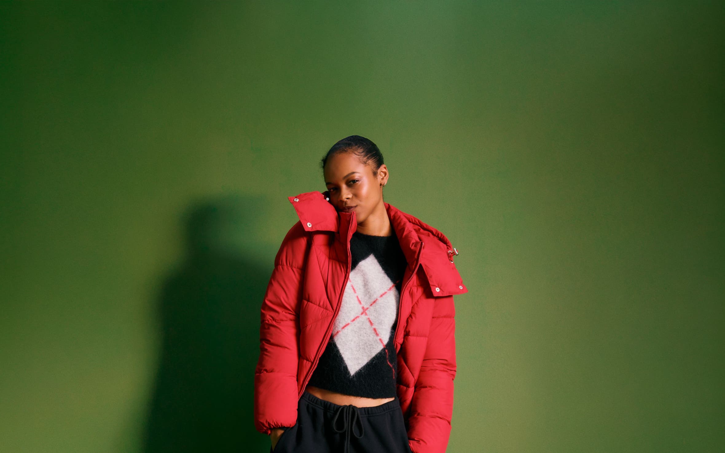 Woman wearing a puffer, sweater and sweatpants.